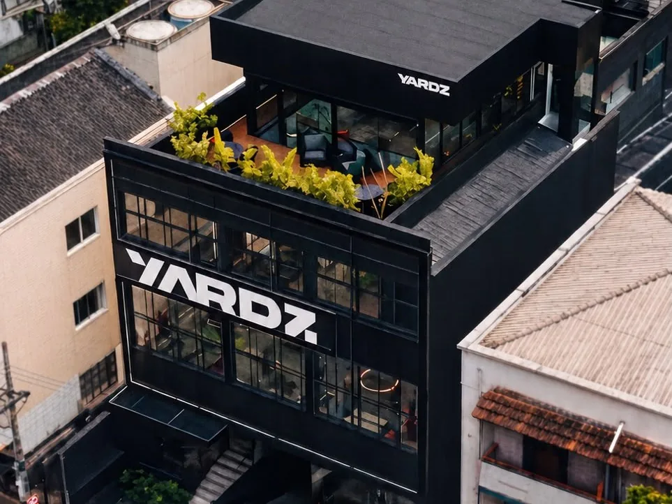 Vista aérea do prédio da YARDZ nos Jardins, com o rooftop arborizado no topo