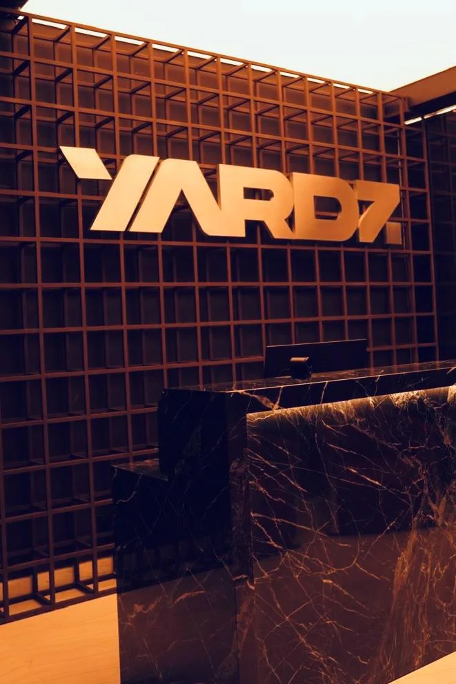 Recepção da YARDZ, com balcão de mármore e o logo na parede