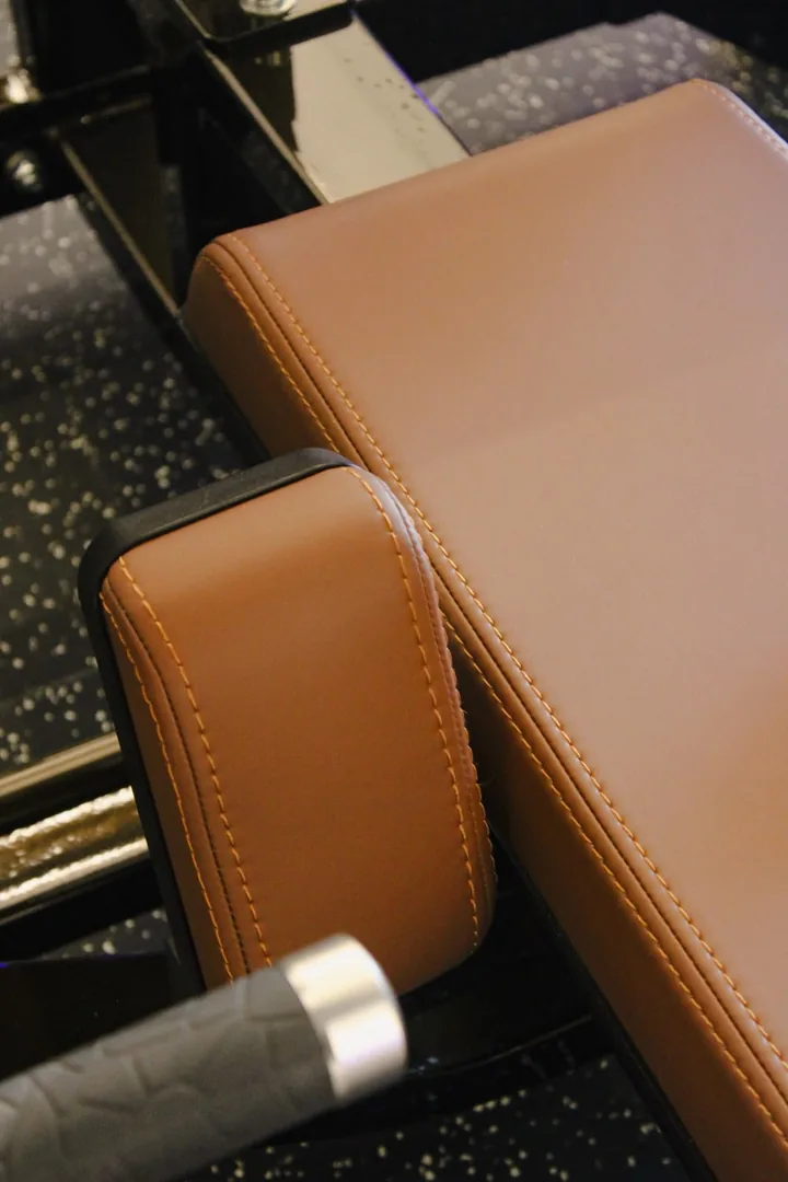 Detalhe do estofado caramelo costurado de um banco de musculação