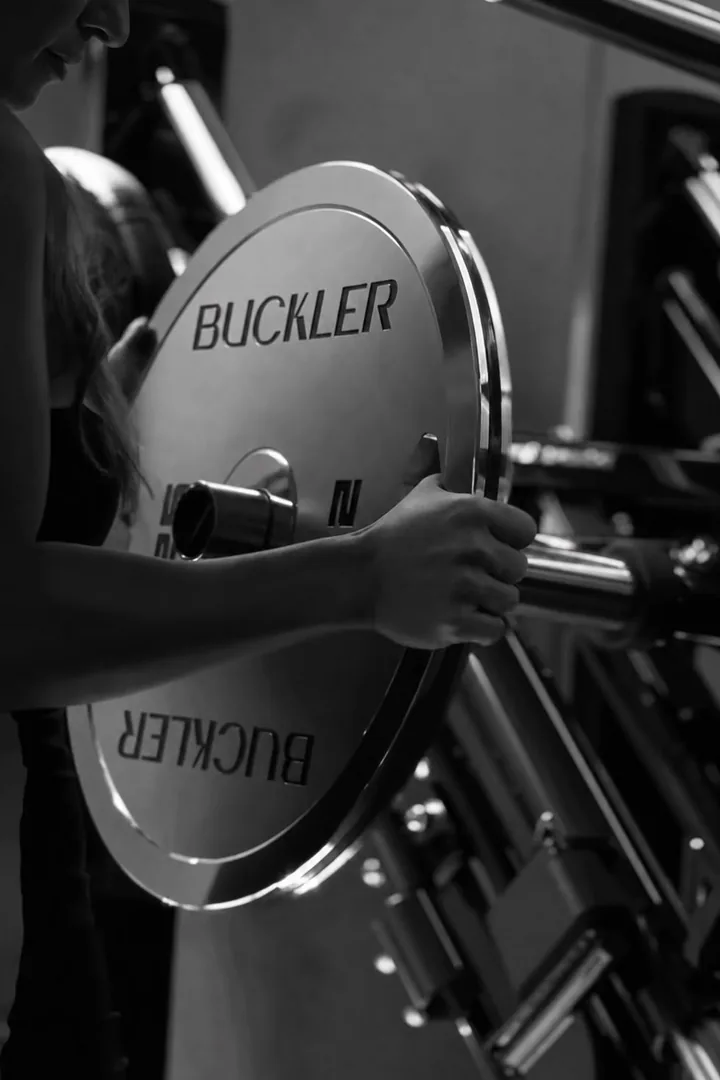 Aluna encaixando uma anilha Buckler na máquina, em preto e branco